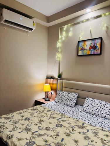 a bedroom with a bed and a tv on the wall at Apex Hub in Greater Noida