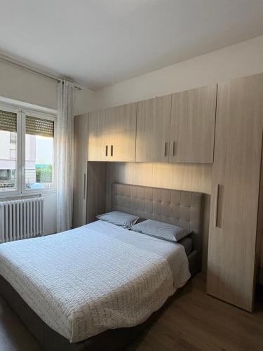 a bedroom with a large bed and wooden cabinets at Casa del Pepo in Segrate