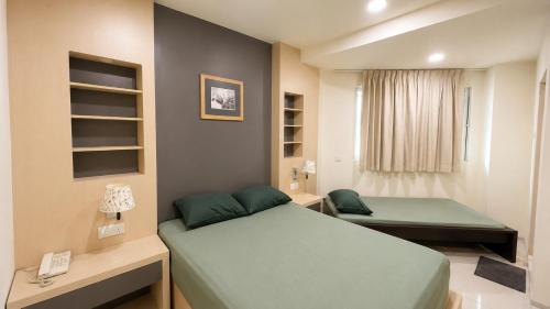 a small bedroom with two beds and a window at JSD Hotel in Petaling Jaya