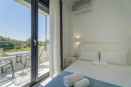 a bedroom with a bed and a balcony at SithoniaRS Sea Nomad Luxury Maisonette in Nikiti