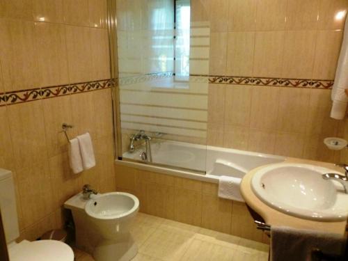 a bathroom with a toilet and a sink and a tub at Solar da Salvadoura in Amares