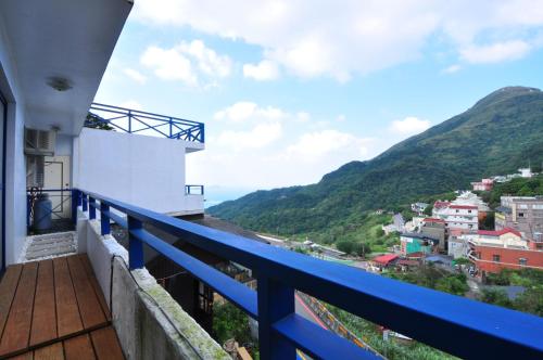 a balcony of a house with a blue railing at Aegean Sea Guest House in Jiufen