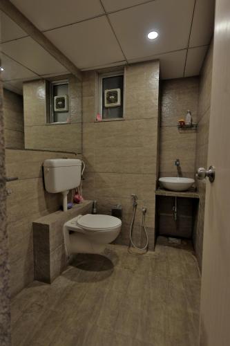 a bathroom with a toilet and a sink at Weekend Address By Farmville in Surat