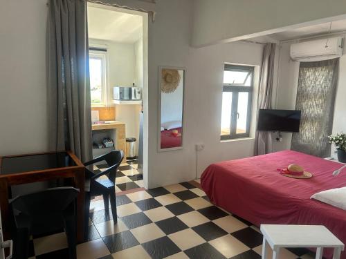 a bedroom with a red bed and a checkered floor at Eagles Nest Residence - Apartment 2 in Rodrigues Island