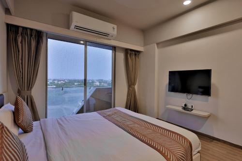 a bedroom with a bed and a large window at Weekend Address By Farmville in Surat