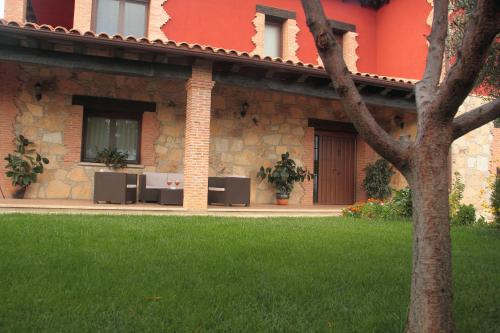 a house with a green lawn in front of it at Casa Rural La Canchalera in Losar de la Vera