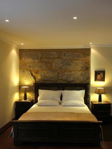 a bedroom with a large bed with two lamps at Solar da Salvadoura in Amares