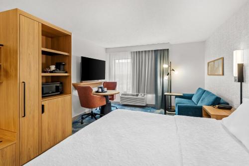 a hotel room with a bed and a living room at Hampton Inn Duluth-Canal Park in Duluth
