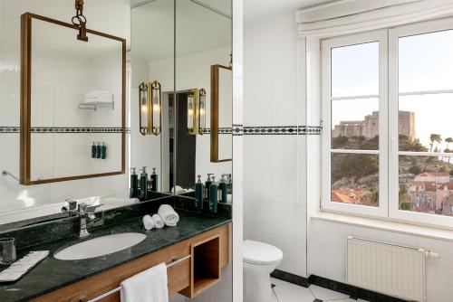 a bathroom with a sink and a toilet and a window at Hilton Imperial Dubrovnik in Dubrovnik