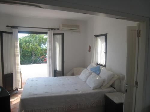 a bedroom with a white bed and a window at Agistri Club Hotel in Skliri