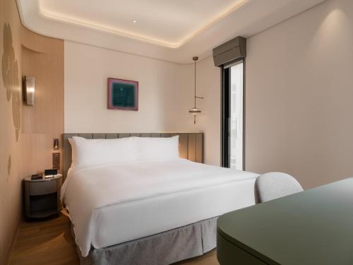a bedroom with a large white bed and a table at 亞士都酒店 in Taipei