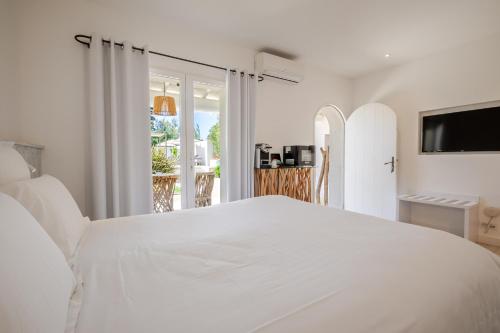a white bedroom with a large white bed at Mas des Cabidoules in Saintes-Maries-de-la-Mer