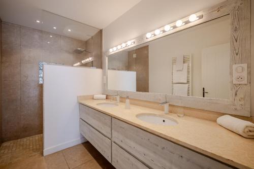 a bathroom with two sinks and a large mirror at Mas des Cabidoules in Saintes-Maries-de-la-Mer