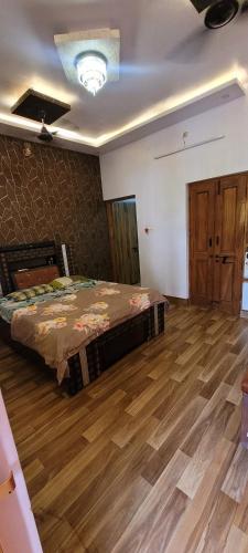 a bedroom with a bed and a wooden floor at Casa Aura in Lucknow