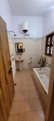 a bathroom with a bath tub and a sink at Casa Aura in Lucknow