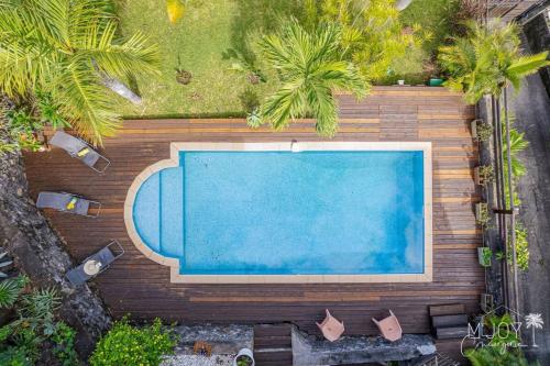 an overhead view of a swimming pool with palm trees at Villa Stella in Saint-Leu
