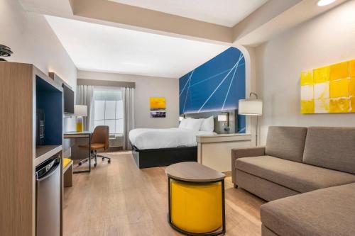a hotel room with a bed and a couch at Comfort Inn & Suites Saint Louis Lafayette Square in Saint Louis