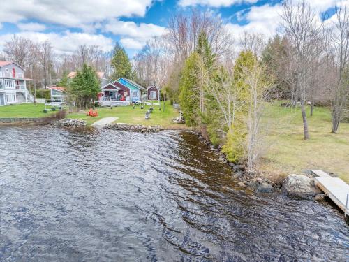 a view of a river with houses in the background at Spa Relaxation & Adventure - Lapointe du Lac in Saint-Gérard