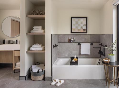 a bathroom with a tub and a sink at Casa Mani Resort Napa Valley, Curio Collection By Hilton in Napa