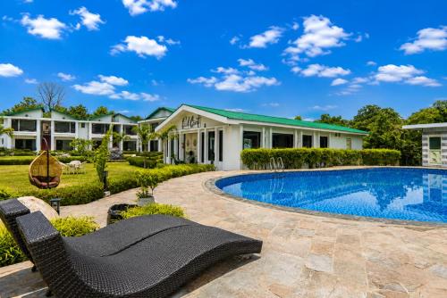 ein Haus mit Swimmingpool und einem Haus in der Unterkunft Baris river resort Corbett in Rāmnagar