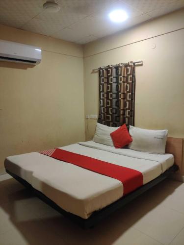 a bedroom with a large bed with red and white pillows at Hotel O CANARIES RETIREES RESIDENCY in Kottakupam