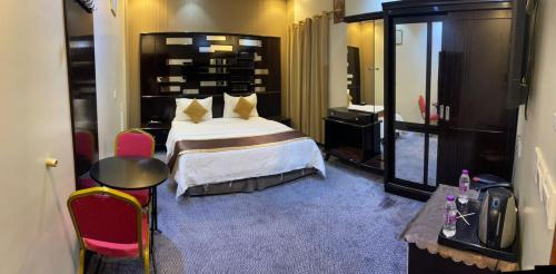a hotel room with a bed and a table and chairs at ABHASKY Serviced Apartmentsشقق مخدومة اقتصادي in Abha
