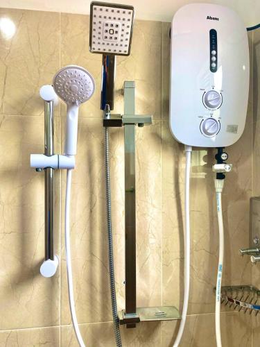 a bathroom with a shower and a hair dryer at Sun and Waves Beach Cottage Ahungalla in Ahungalla