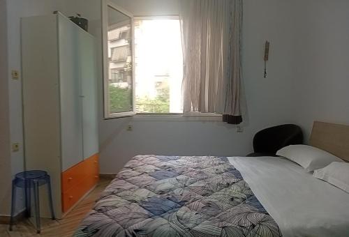 a bedroom with a bed and a window at Enki's Garden in Tirana