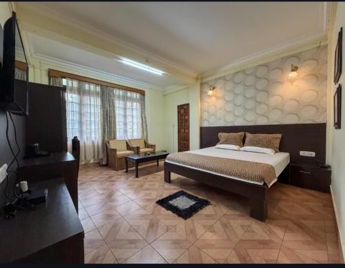 a bedroom with a bed and a living room at Apsara Guest House, Peaceful Area in Central Shillong in Shillong