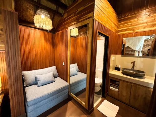 a bathroom with a toilet and a sink and a mirror at Bali Hidden Lemukih in Sawan