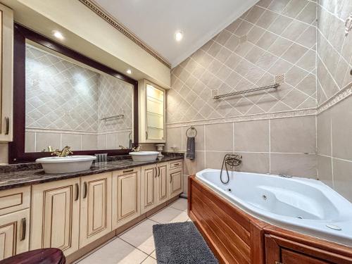 a bathroom with two sinks and a tub at BondMakers Hidden Gem in Hartbeespoort
