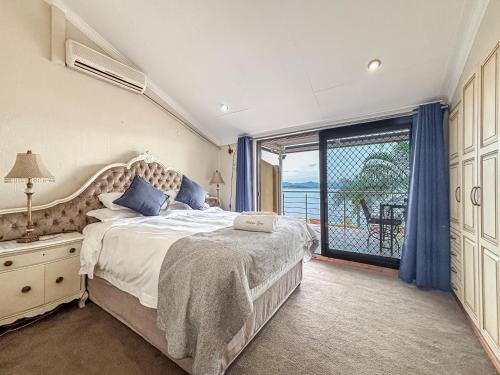 a bedroom with a large bed and a balcony at BondMakers Hidden Gem in Hartbeespoort