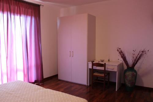 una camera da letto con armadio bianco e scrivania di Il Mandorlo B&B a Civitanova Alta