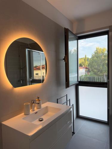 a bathroom with a white sink and a mirror at Villa Karpa in Pridraga