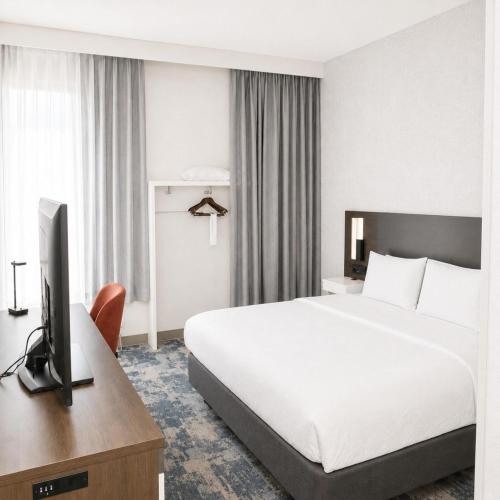 a hotel room with a bed and a television at Hampton Inn Summersville in Summersville