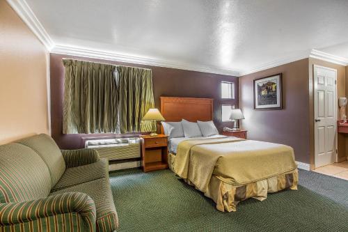a hotel room with a bed and a couch at Rodeway Inn Ventura Midtown in Ventura