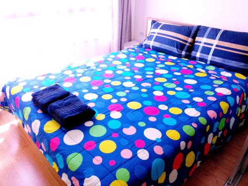 - un lit avec des draps en points de polka au-dessus dans l'établissement Lumpini Ville Top Floor, à Pattaya (nord)