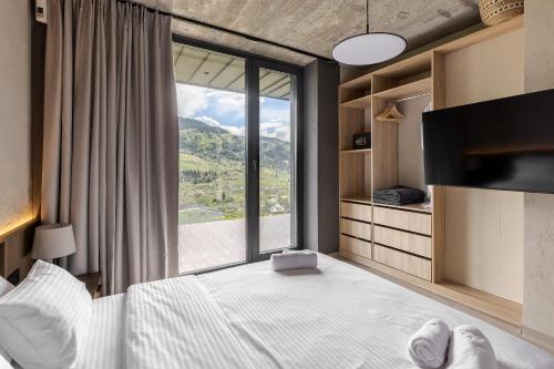 a bedroom with a bed and a large window at Krasnyk Resort in Verkhovyna