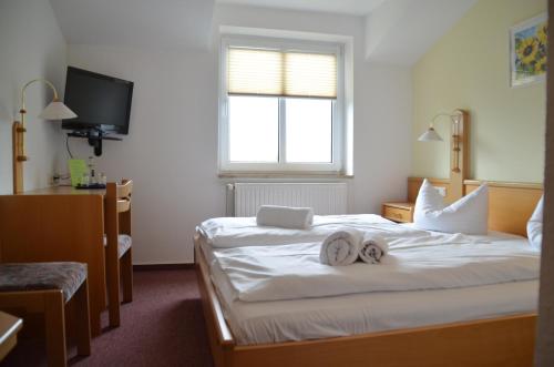 a hotel room with two towels on a bed at Hotel-Pension Pastow Garni in Broderstorf
