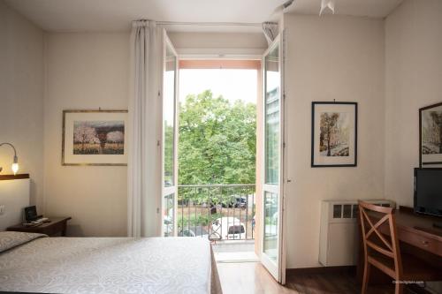 a bedroom with a bed and a sliding glass door at Hotel Blumen in Bologna