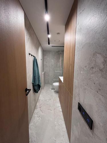 a bathroom with a toilet and a sink and a door at Marių vilos apartamentai Balcony with a Lagoon View in Juodkrantė