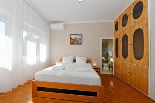 a bedroom with a large bed with a wooden headboard at Blackbird Apartment in Balatonfüred