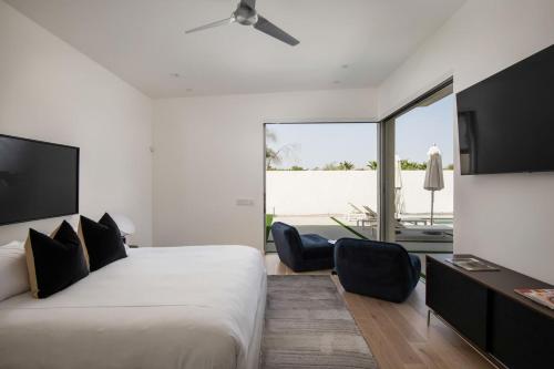 a bedroom with a bed and a desk with chairs at Mercury @ Elemento49 - Pool Spa - Sleeps 16 in Indio