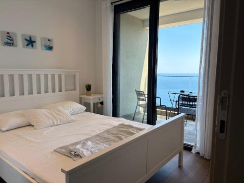 a bedroom with a bed and a view of the ocean at Panoramic Sea View in Budva