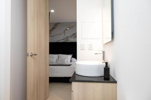 a bathroom with a sink and a bed at Sky Luxury Residence, 12th Floor, Panoramic in Guadalajara