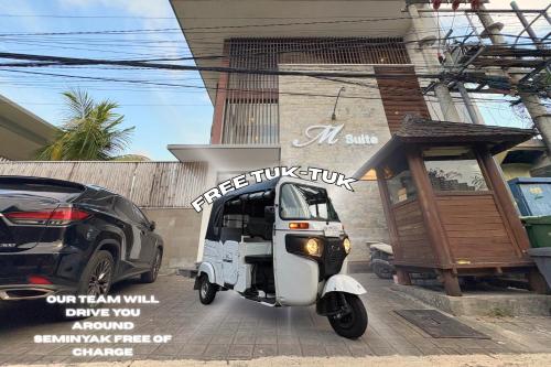 a white scooter parked in front of a building at M Suite Bali in Seminyak