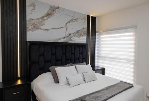 a bedroom with a white bed with a black headboard at Sky Luxury Residence, 12th Floor, Panoramic in Guadalajara