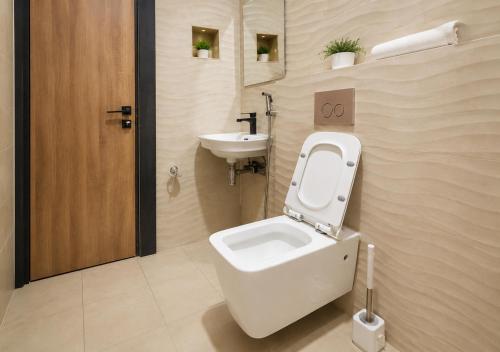 a bathroom with a toilet and a sink at The Savannah Hotel, Garki in Abuja