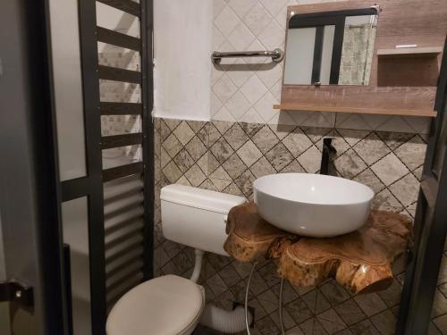 a bathroom with a toilet and a sink on a log at Entre Vallee Eco lodge in Port Mathurin