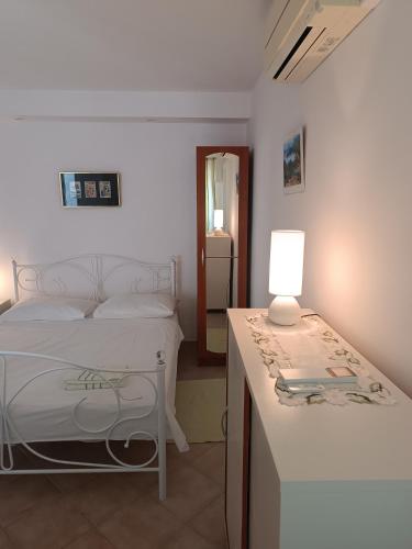 a bedroom with a bed and a table with a lamp at Apartments Biba & Lucy in Ražanac